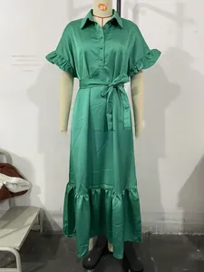 Détail de la robe en satin vert émeraude avec jupe à étages et poignets à volants