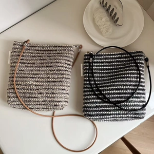 Flat lay of vintage striped tweed crossbody bags with simple wish label on white surface