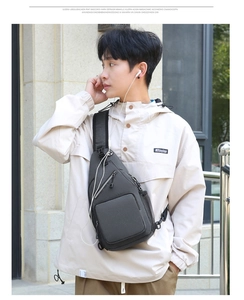Detail of grey crossbody bag featuring a side headphone port and secure zipper pocket