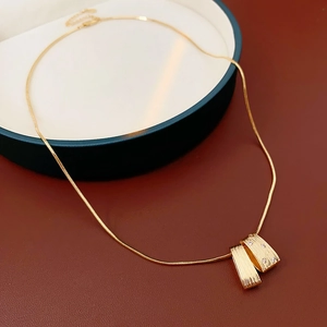 Macro shot of gold snake chain necklace with irregular cubic zirconia geometric pendant