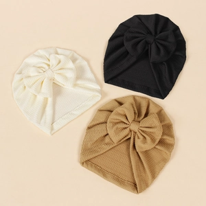 Detail of ribbed knit baby turbans with large bows in white, black and khaki colors