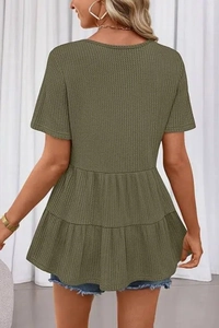 Détails du tissu gaufré et de l'ourlet à basque sur un haut pour femme vert olive