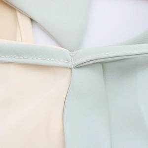 Sleeveless halter neck pleated dress in mint green and beige with detailed stitching