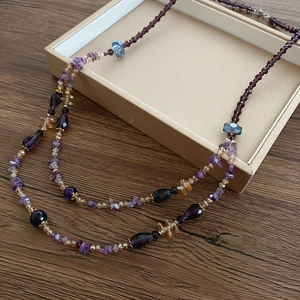 Detail einer zweilagigen Boho-Halskette mit Amethyst-Steinen und bunten Glasperlen