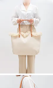 Close-up of the beige canvas tote bag with fringe edge and brown leather handle details