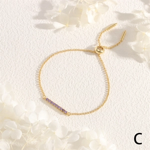 Detail of adjustable gold slider bracelet with sparkling purple cubic zirconia stones