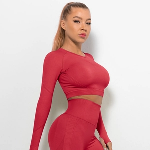 Dettaglio del set da yoga rosso senza cuciture con leggings a vita alta e asole per pollici