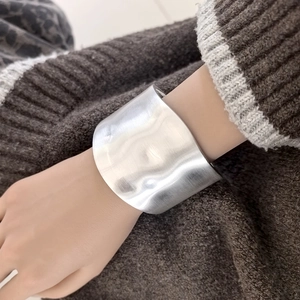Detail of silver brushed metal cuff bracelet with minimalist irregular geometric design