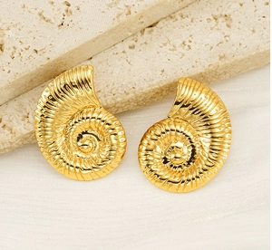 Macro detail of conch shell shaped gold earrings with textured spiral grooves on stone