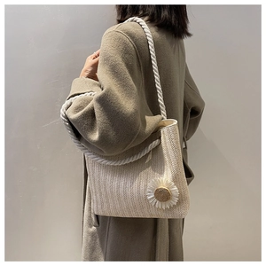 Detail of woven straw bag with white daisy flower and thick cotton rope strap
