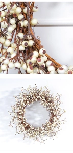 Detailed close-up of a rustic Christmas wreath featuring white berries and brown vines