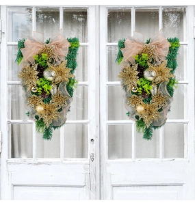 Details von gold-rosa Weihnachtsanhängern mit Kiefernadeln an weißen Türen