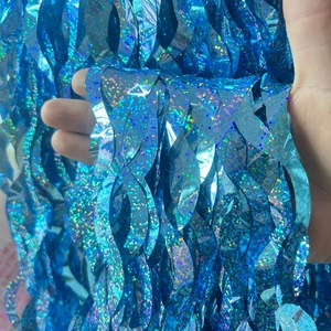 Close-up of blue holographic foil fringe curtain with wave cut and glitter texture