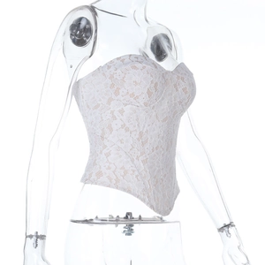 Close-up of intricate white lace floral embroidery on corset top with beige lining