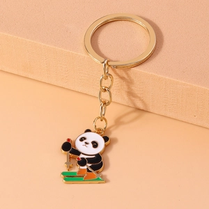 Close-up of cute enamel panda keychain with green ski board on orange background