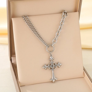 Détail du collier à pendentif croix rétro argenté avec fermoir OT sur écrin beige