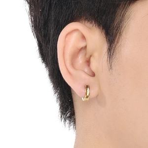 Close-up of minimalist gold titanium steel earring with zircon inlay worn by a model