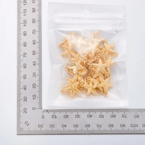 Golden starfish metal charms in a 7x9cm bag with scale measurements for size