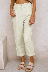 Detail der cremefarbenen Cordstruktur und Knopfverschluss an der geraden Hose