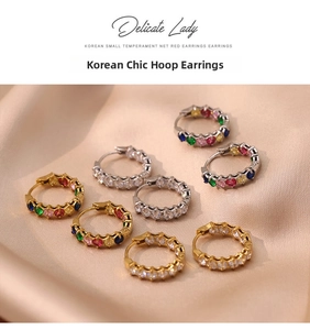 Detail of four luxury French-style hoop earrings with colorful zircons on silk background