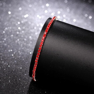 Macro shot of a 2.0mm single row red rhinestone tennis bracelet on a black display stand