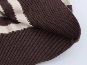 Detailed macro view of the striped knit texture in deep brown and beige ribbed fabric