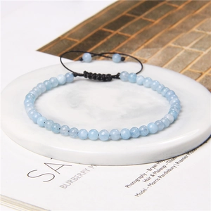 Detail of 4mm light blue natural stone beads on an adjustable hand-woven black cord bracelet