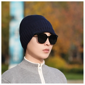 Close-up of deep blue ribbed knit beanie on male model for winter warmth outdoors
