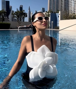 Detailed view of 3D white floral applique on luxury black one-piece swimsuit