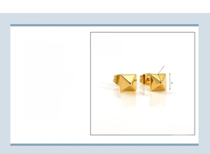 Détail macro de boucles d'oreilles pyramides en acier inoxydable plaqué or 18 carats