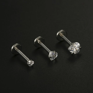 Macro detail of three heart-shaped zircon labret studs in silver titanium steel