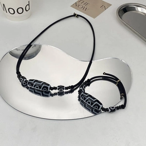 Minimalist nine-eyed Dzi bead necklace and bracelet set with black braided rope and mirror reflection