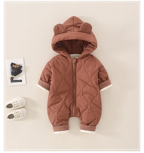 Detail of baby quilted jumpsuit featuring bear ears hood and warm ribbed cuffs
