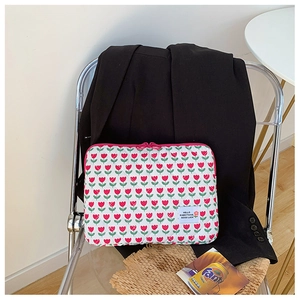 Close-up of quilted floral laptop sleeve with tulip pattern and pink zipper detailing