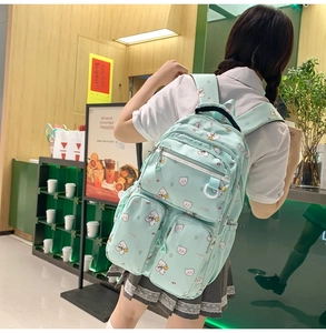 Detail of mint green school backpack featuring cute bear patterns and padded straps