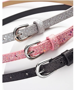 Close-up of glitter skinny belts in silver, pink, and black with metallic pin buckles