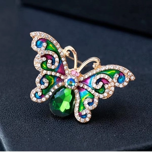 Primer plano detallado de broche de mariposa de esmalte colorido con pedrería y un cristal.