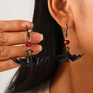 Detail of bat-shaped gothic earring with red beads worn by a model for Halloween style