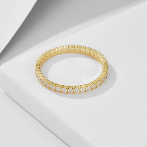 Elegant gold eternity ring with micro-pave zircons on minimalist geometric background