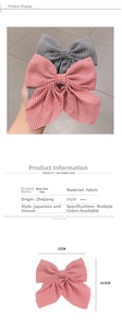 Detail view of a red and white checkered bow hair clip with size dimensions 12cm by 13.5cm