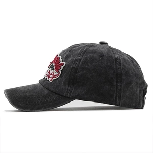Close-up of vintage washed black cotton baseball cap with red and white 3D embroidery