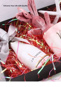 Close-up of iridescent red shredded paper filler inside a black luxury gift box