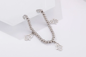 Detail of silver double-layer beaded bracelet with three Hamsa hand charms for women