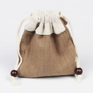 Dettaglio della borsa porta gioielli in lino con cuciture beige e perline in legno