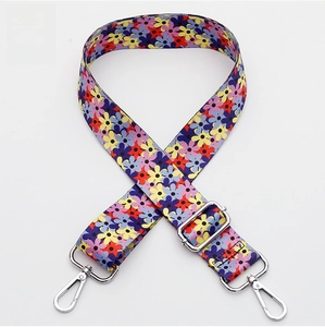 Detailed view of silver lobster clasps and floral woven strap for crossbody bags