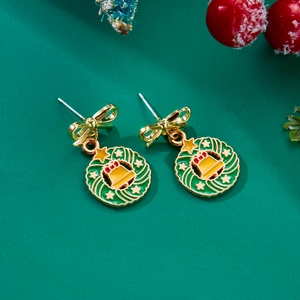 Festive Christmas wreath earrings with gold bows and bells on holiday background