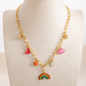 Detail of gold link chain necklace featuring rainbow and heart charms on a jewelry bust