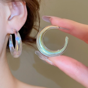 Detailed view of iridescent acrylic C-shape hoop earrings showing vibrant aurora color glow
