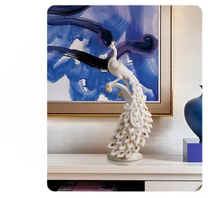 Detail of white peacock art sculpture with golden accents on a minimalist cabinet