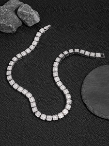 Macro shot of 13mm silver hip hop Cuban link chain with shiny rhinestones on black leather